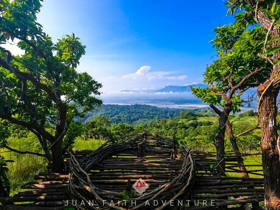 A designated photo spot along the Mt. Kapigpiglatan day hike trail, offering a clear view of the surrounding mountain ranges in Zambales Province.