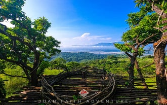 A designated photo spot along the Mt. Kapigpiglatan day hike trail, offering a clear view of the surrounding mountain ranges in Zambales Province.