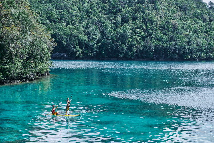 Tourists paddleboarding in Sugba Lagoon, which you can try on this Siargao Island tour