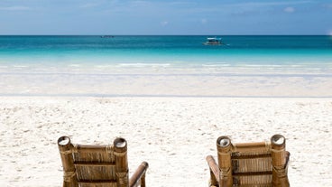 A relaxing view of a white sand beach is included in your 4-day, 3-night Boracay Island tour package with airfare