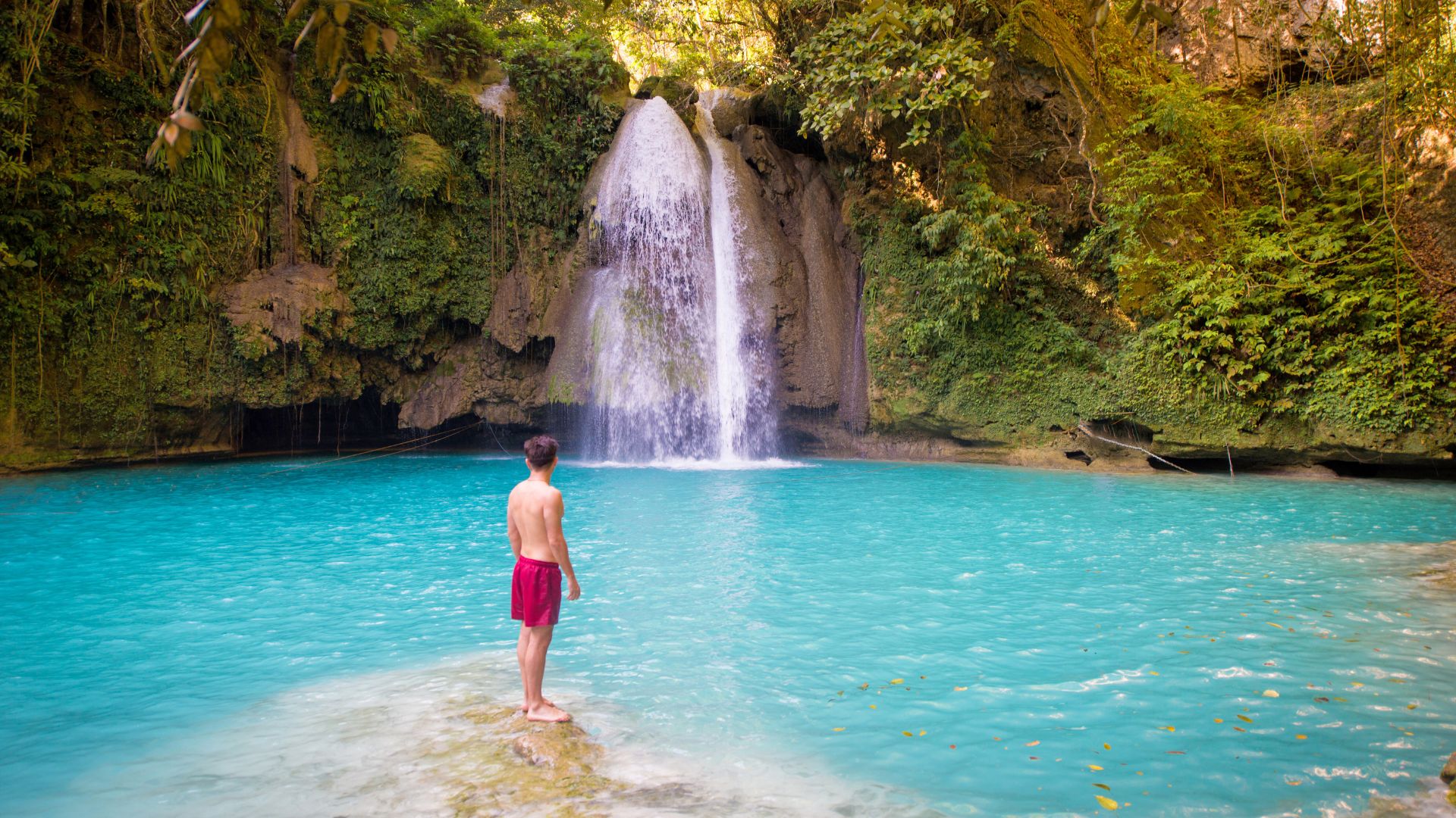 Discover Kawasan Falls: stunning turquoise waterfalls surrounded by lush greenery and natural pools.