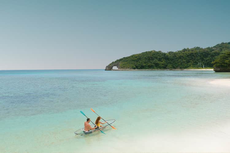 Two tourists enjoying the calm waters on a crystal kayak ride in Boracay Island