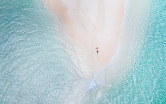 Relaxing on the stunning sands of Naked Island, included in a vacation package to Siargao Island