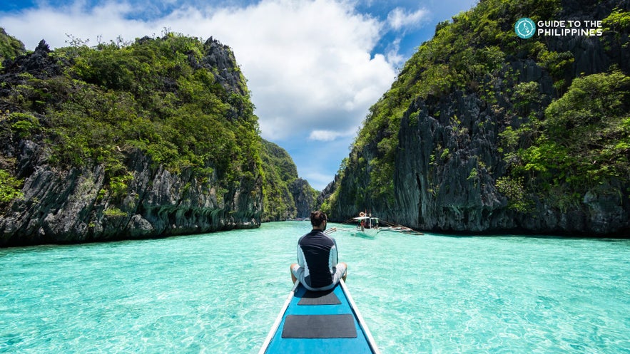 A tourist on a boat during an El Nido island hopping tour in Big Lagoon on Palawan A tourist on a boat during an El Nido island hopping tour in Big Lagoon on Palawan