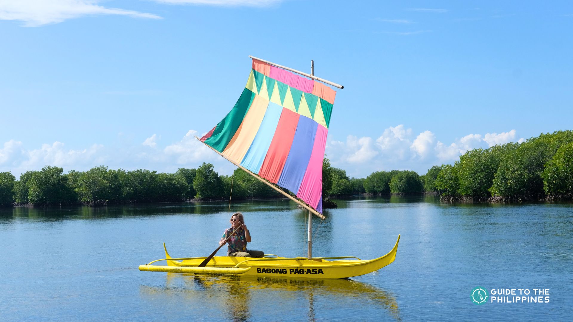 A traveler happily rowing a traditional vinta sailing boat in Zamboanga City.