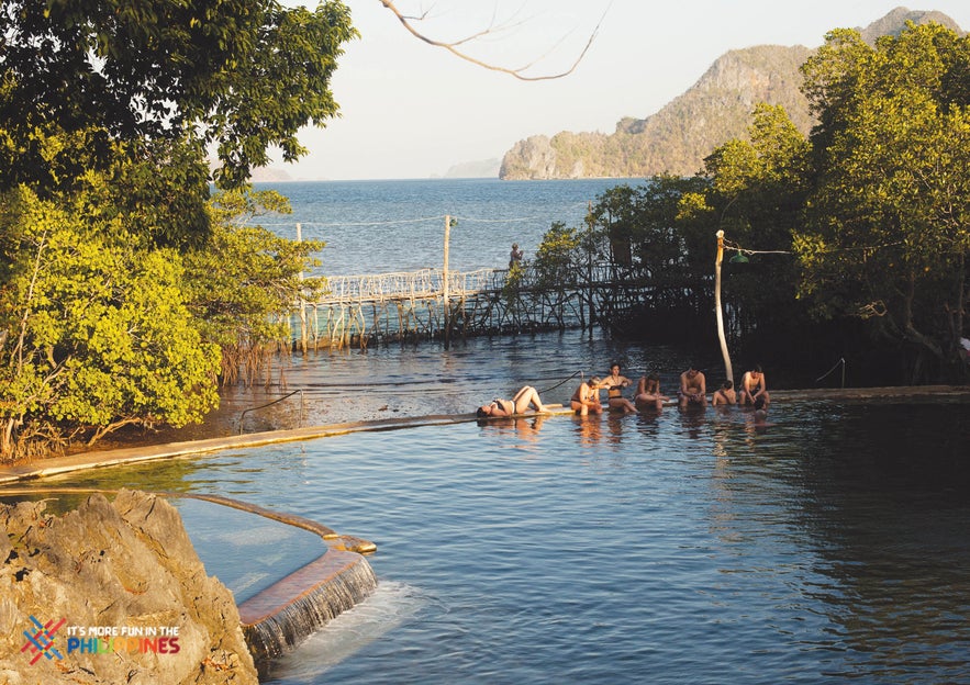 Travelers relax in Maquinit Hot Spring in Coron town on Palawan Island.  Travelers relax in Maquinit Hot Spring in Coron town on Palawan Island.