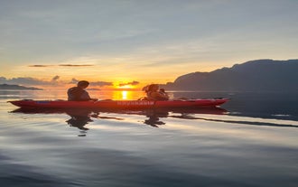 Witness the sunrise as you kayak in Coron town, gliding through calm morning waters.