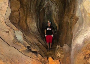 A solo adventurer pauses for breath, illuminated by cave light on a steep path during this tour in Puerto Princesa City.