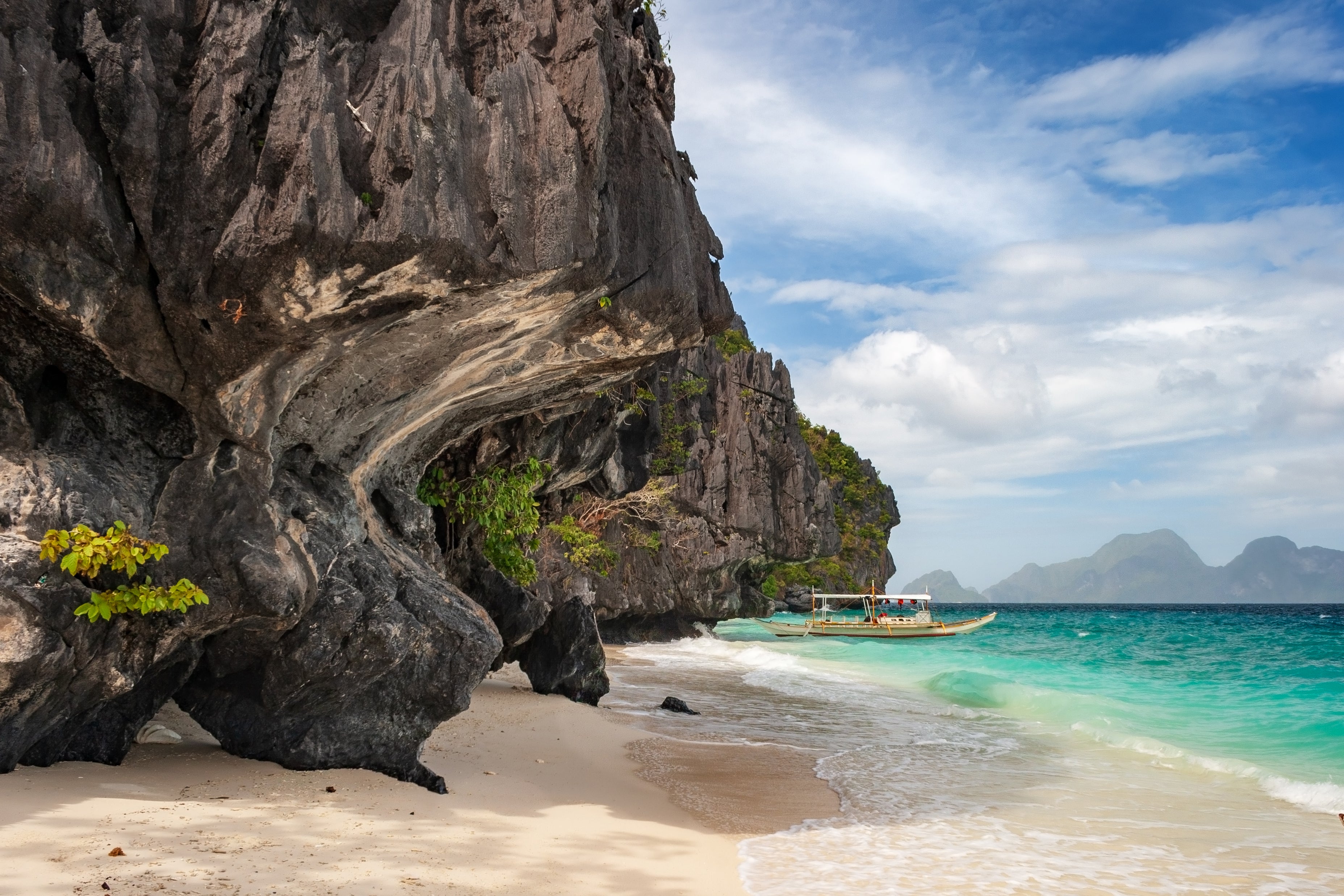 The pristine white sand beach and blue waters of Entalula Island is part of your tour package at El Nido town.