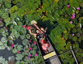 Smiling together, a couple admires blooming flowers in the Lotus Garden during a peaceful boat ride on this private tour to Lake Sebu Municipality in South Cotabato Province.