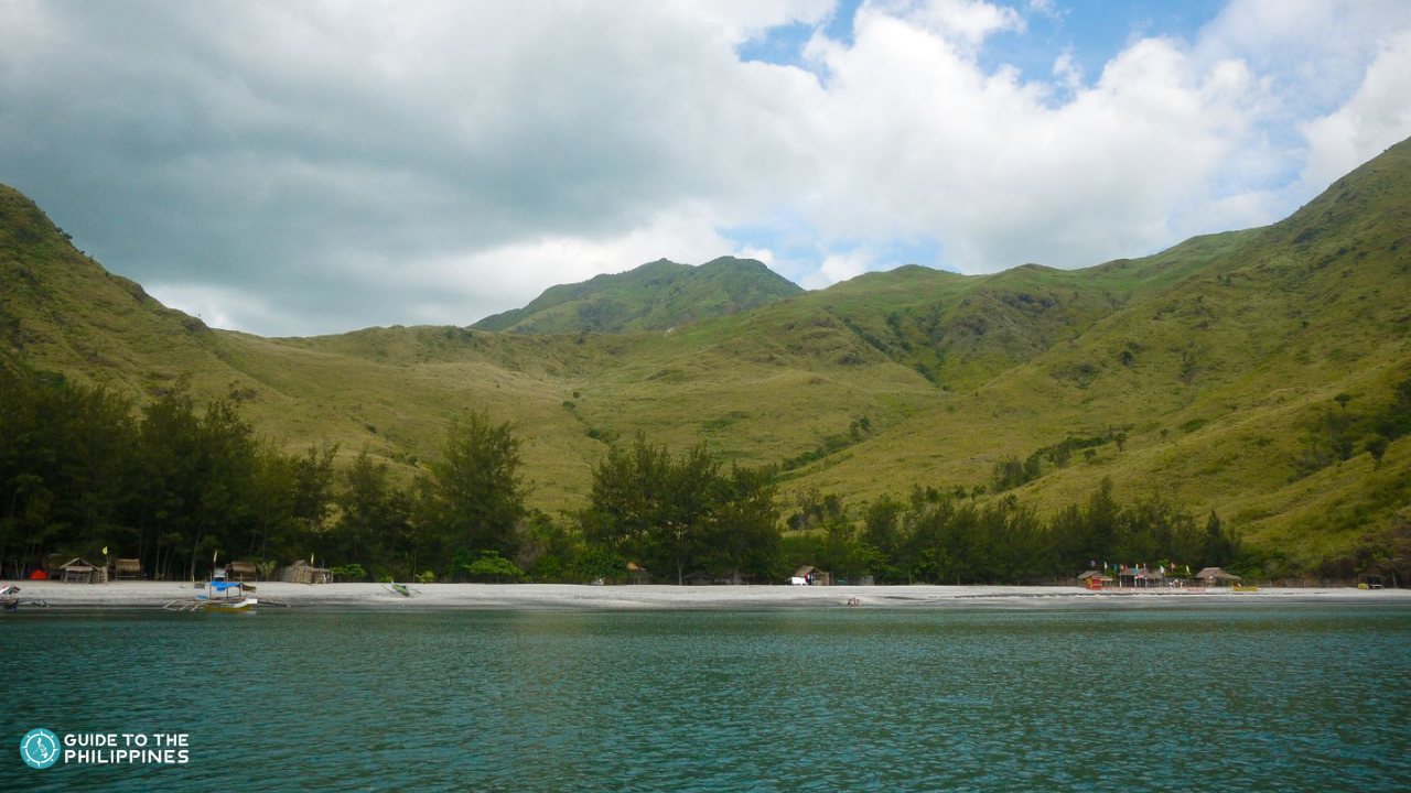 A beautiful view of the calm crystal clear waters and majestic hills of Nagsasa Cove in Zambales Province.