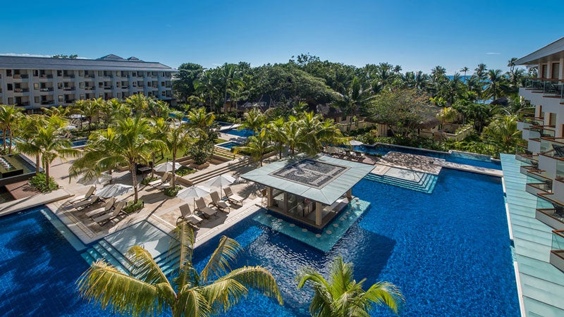 Henann Resort Alona Beach&rsquo;s sparkling swimming pool flanked by stylish loungers
