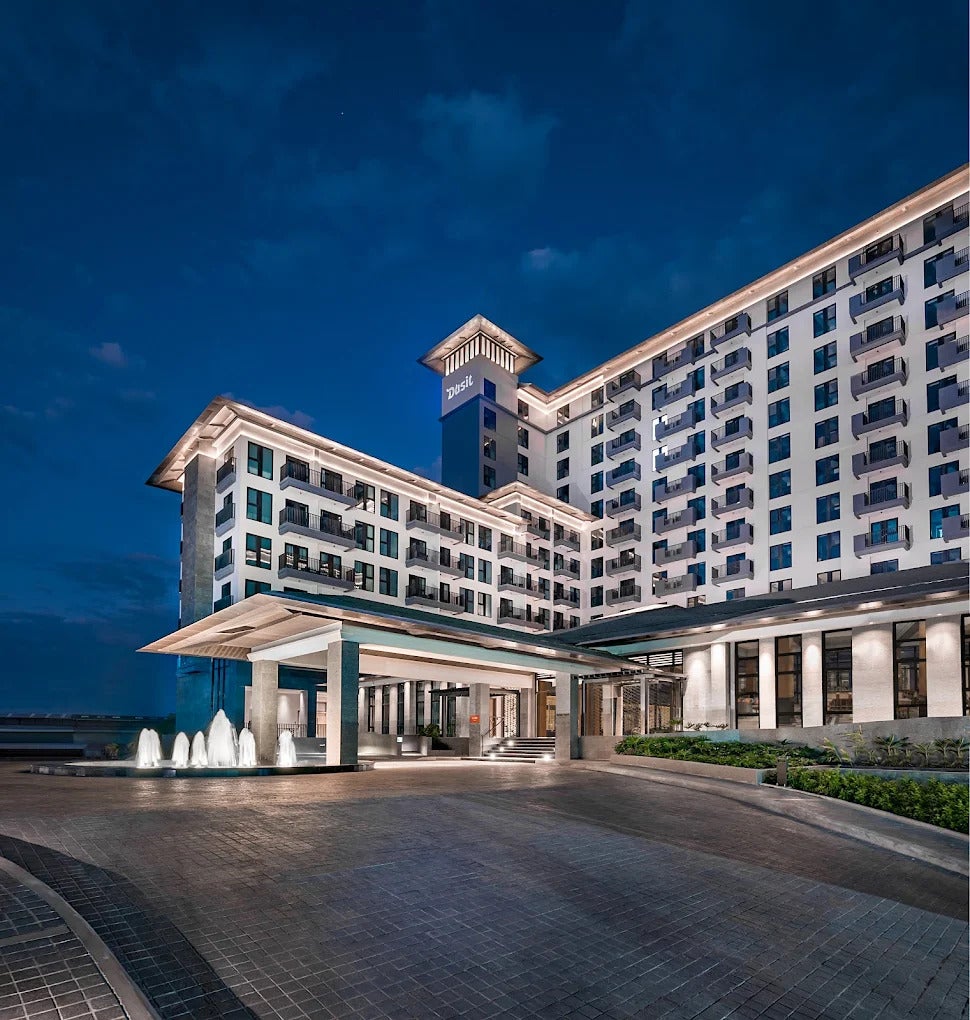 Dusit Thani Residence Davao&rsquo;s elegant facade, guiding guests toward its inviting entrance."